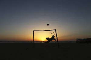 A boy jumps to save a goal while playing soccer on the beach in Benghazi A boy jumps to save a goal while playing soccer on the beach in Benghazi