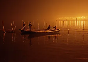 Boys tie their boats as fog covers the banks of the Yamuna river on a cold evening Boys tie their boats as fog covers the banks of the Yamuna river on a cold evening
