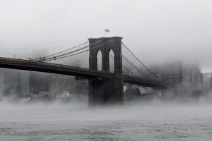 The Brooklyn Bridge is seen partially in fog from in front of the Manhattan skyline The Brooklyn Bridge is seen partially in fog from in front of the Manhattan skyline