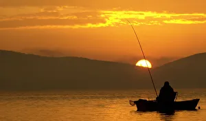 A Bulgarian fisherman rows his boat during the early morning at a lake south from Sofia A Bulgarian fisherman rows his boat during the early morning at a lake south from Sofia