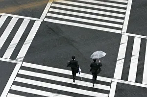 Businessmen run as they cross a street in Tokyo Businessmen run as they cross a street in Tokyo