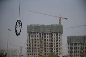 A cable is seen near residential buildings under construction in Beijing A cable is seen near residential buildings under construction in Beijing