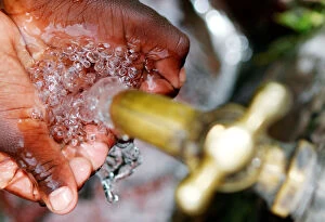 A child prepares to drink clean water from a tap in Kawangware district of Nairobi