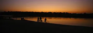 Children ride bicycles during the sunset at the bank of East Rapti River at Sauraha Children ride bicycles during the sunset at the bank of East Rapti River at Sauraha