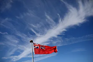 Cirrus clouds and some contrails are seen above a Red Ensign flag on the ferry MS Cirrus clouds and some contrails are seen above a Red Ensign flag on the ferry MS