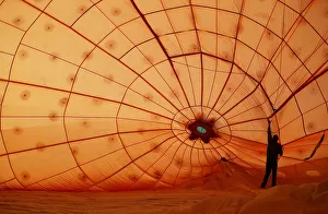 A crew member prepares a hot air balloon before a tethered flight at the Bristol A crew member prepares a hot air balloon before a tethered flight at the Bristol