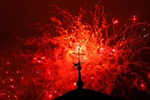A cross of the Basilica of the Agustinas Recoletas is seen as fireworks explode over A cross of the Basilica of the Agustinas Recoletas is seen as fireworks explode over