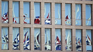 Images Dated 28th July 2010: Cuban flags are reflected of the windows of the Interests Section Office of the United