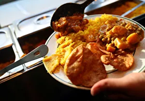 A customer self-serves a plate of food inside the Indian Veg vegetarian restaurant A customer self-serves a plate of food inside the Indian Veg vegetarian restaurant