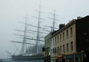 The Cutty Sark is pictured behind buildings at Greenwich in London
