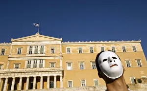 A demonstrator wearing a mask protests in front of the parliament in Athens A demonstrator wearing a mask protests in front of the parliament in Athens