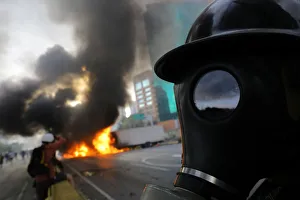 Demonstrators stand near burning trucks while rallying against President Nicolas Maduro Demonstrators stand near burning trucks while rallying against President Nicolas Maduro