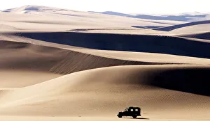 A DESERT TERRAIN VEHICLE CROSSES THE SAND DUNES AT SIWA OASIS IN EGYPT A DESERT TERRAIN VEHICLE CROSSES THE SAND DUNES AT SIWA OASIS IN EGYPT