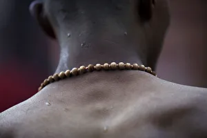 A devotee wearing prayer beads returns after taking a holy bath at the Saali River on the A devotee wearing prayer beads returns after taking a holy bath at the Saali River on the