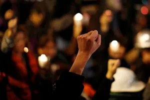 Earthquake victim gestures during a minute of silence with others as they mark the Earthquake victim gestures during a minute of silence with others as they mark the
