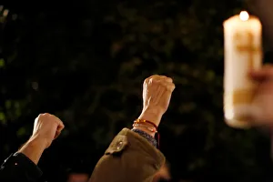 Earthquake victims gesture during a minute of silence as they gather to mark the Earthquake victims gesture during a minute of silence as they gather to mark the