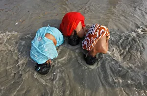Female Hindu pilgrims take a dip at the confluence of the Ganges river Female Hindu pilgrims take a dip at the confluence of the Ganges river