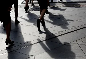 Commuter Gallery: Female office workers wearing high heels and clothes of the same colour walk at a