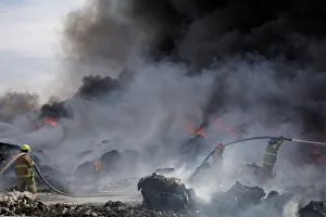 Juarez Gallery: Firefighters work to extinguish the fire as it burns through a pile of old tyres at a