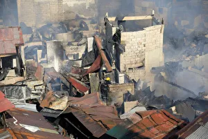 A fireman fights fire at shanties in a residential area near the Malacanang presidential A fireman fights fire at shanties in a residential area near the Malacanang presidential