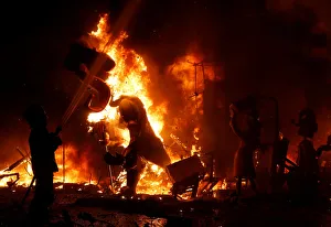 A fireman sprays water at figures of a monument as it burns during the finale of the A fireman sprays water at figures of a monument as it burns during the finale of the