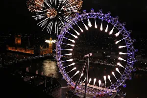 Fireworks explode from The Big Ben clock tower and the London Eye during New Year Fireworks explode from The Big Ben clock tower and the London Eye during New Year