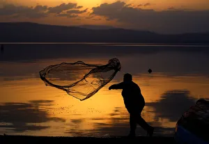 A fisherman uses his net at Lake Ohrid in Ohrid A fisherman uses his net at Lake Ohrid in Ohrid