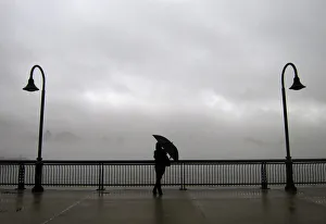 Fog shrouds the skyline of New York as a woman stands next to the Hudson River on a pier Fog shrouds the skyline of New York as a woman stands next to the Hudson River on a pier