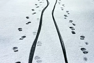 Images Dated 8th December 2014: Footprints and cycle tracks are seen on a snowy road in Buxton