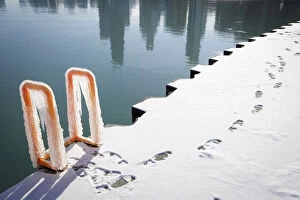 Seasons Gallery: Footprints can be seen along the ice covered shore as the reflection of the skyline