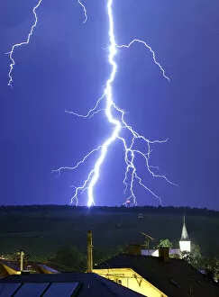 A fork of lightning strikes a mountain during a thunderstorm near the town of Barr south