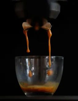 Freshly ground Arabica coffee drips from a domestic coffee machine to make an espresso Freshly ground Arabica coffee drips from a domestic coffee machine to make an espresso