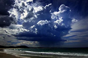 A giant storm cloud can be seen in the sky above swimmers near Mollymook Beach, south A giant storm cloud can be seen in the sky above swimmers near Mollymook Beach, south