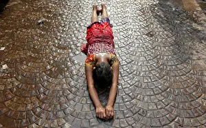 A girl lies on a road as she performs a ritual while worshipping Sheetala Mata A girl lies on a road as she performs a ritual while worshipping Sheetala Mata