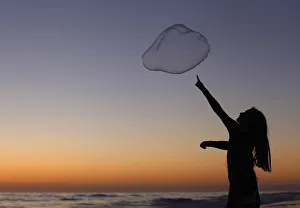 A girl plays with a giant bubble as the sun sets at Moonlight Beach in Encinitas A girl plays with a giant bubble as the sun sets at Moonlight Beach in Encinitas