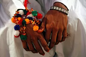 A groom wears a traditional handmade garland on his wrist