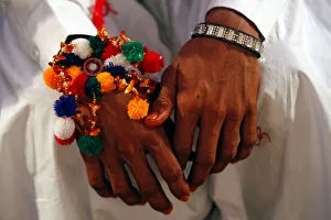 A groom wears a traditional handmade garland on his wrist A groom wears a traditional handmade garland on his wrist