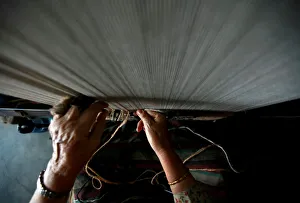 A hand of a Tibetan refugee is pictured as she works to weave a traditional carpet A hand of a Tibetan refugee is pictured as she works to weave a traditional carpet