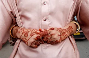 The hands of a girl, adorned with henna patterns, as she arms around her father while The hands of a girl, adorned with henna patterns, as she arms around her father while