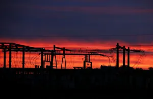 High-tension electrical power pylons are seen in silhouette as the eastern sky brightens High-tension electrical power pylons are seen in silhouette as the eastern sky brightens