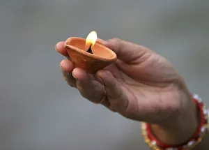 A Hindu devotee holds an earthen lamp as she offers prayers to the Sun god in Siliguri A Hindu devotee holds an earthen lamp as she offers prayers to the Sun god in Siliguri