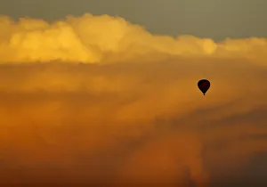 A hot air balloon floats past a distant thunderstorm after sunset near San Diego A hot air balloon floats past a distant thunderstorm after sunset near San Diego
