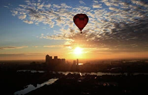 Related Images Collection: A hot air balloon rises into the early morning sky in front of the Canary Wharf financial