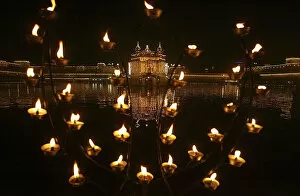 Illuminated holy Sikh shrine of Golden temple is seen through decoration of oil lamps