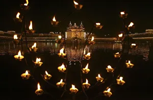 Illuminated holy Sikh shrine of Golden temple is seen through decoration of oil lamps Illuminated holy Sikh shrine of Golden temple is seen through decoration of oil lamps