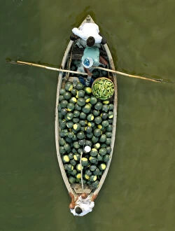 Images Dated 25th April 2006: Indian farmers carry watermelons on a boat across the river Ganges in Allahabad