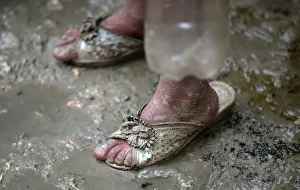An internally displaced Syrian girl stands in the mud after heavy rain at a camp on the An internally displaced Syrian girl stands in the mud after heavy rain at a camp on the