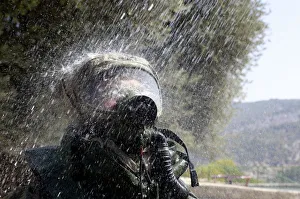 An Israeli soldier wearing a protective gear is sprayed with water during a drill An Israeli soldier wearing a protective gear is sprayed with water during a drill