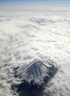 Images Dated 2nd February 2010: Japans Mount Fuji, covered with snow and surrounded by cloud, is seen from an airplane