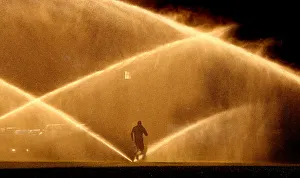 A jogger makes his way past sprinklers in Washington A jogger makes his way past sprinklers in Washington
